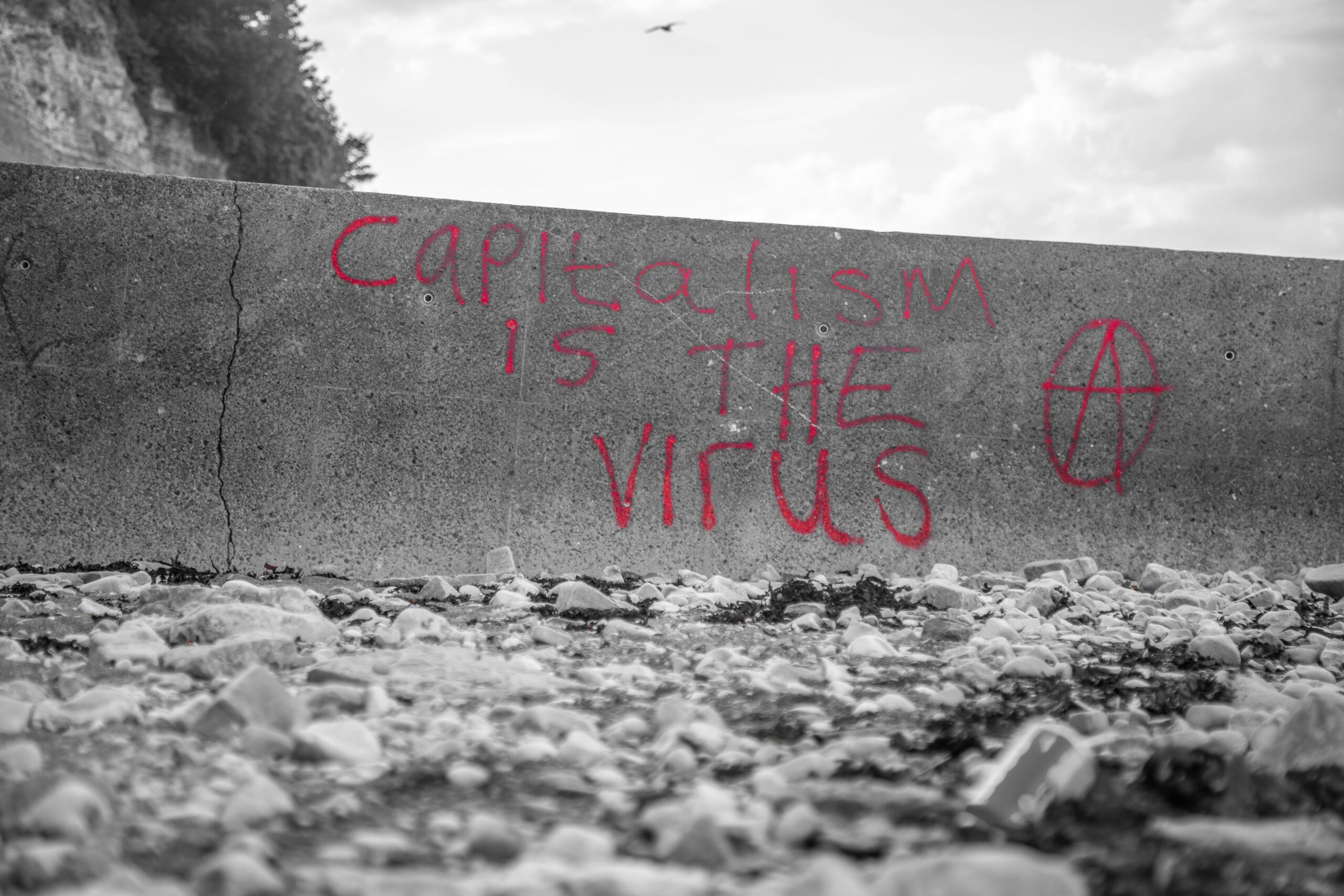 Antikapitalistische Parole auf Betonwand gesprüht: "Capitalism is the virus"